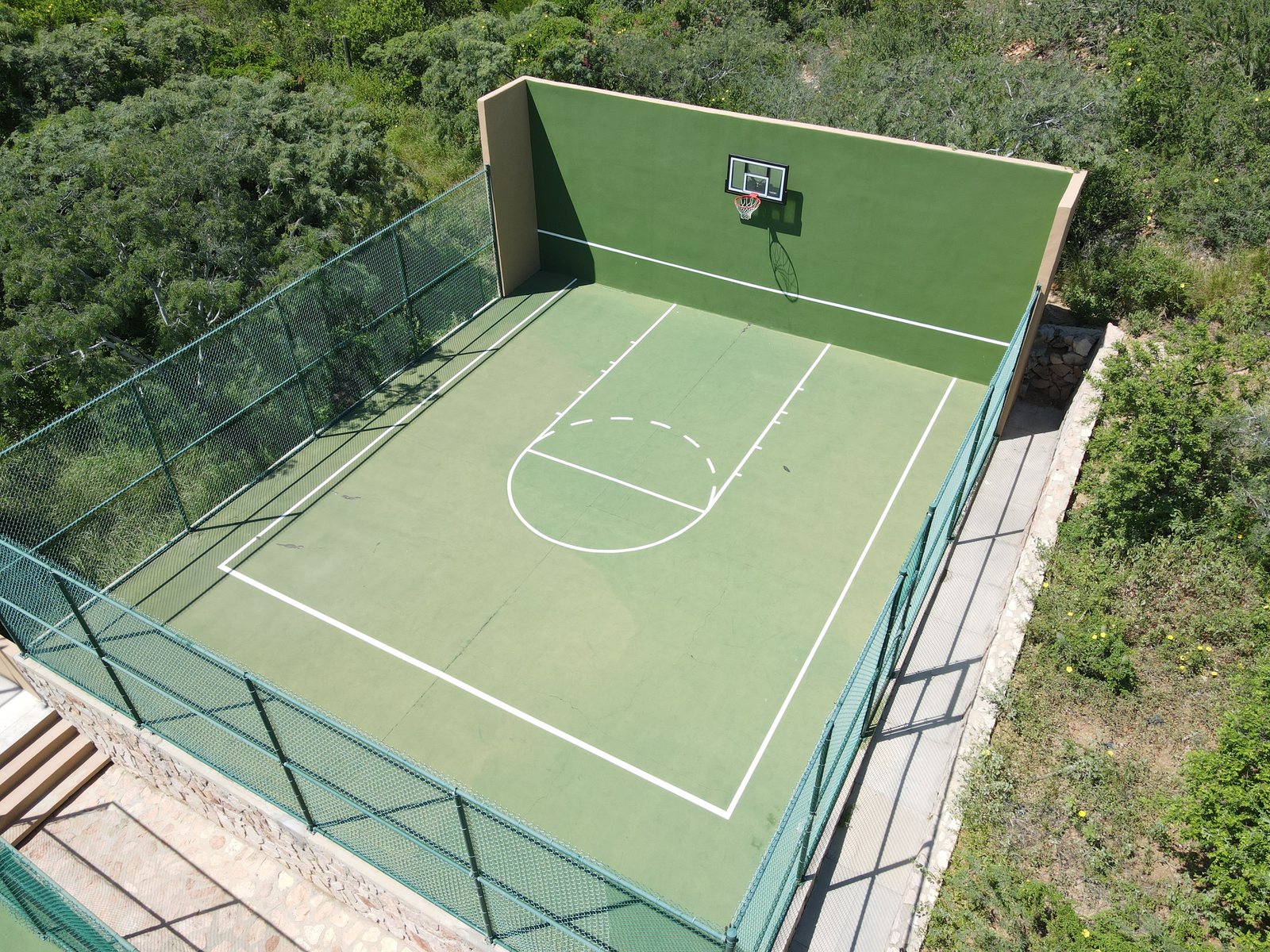Half basketball court with a painted practice wall at Pedregal